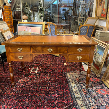 Bucarest Art & Antiques Louis-Philippe mahogany desk with brown leather top, brass hardware, and turned legs.